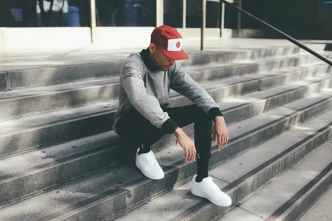Boy in streetwear posing with sunglasses in an outdoor location